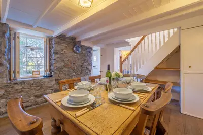 a dining room with a wooden table and chairs at Scrumbles Hollow in St. Agnes