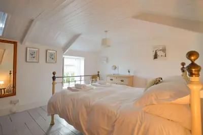 a bedroom with a large white bed in a room at Scrumbles Hollow in St. Agnes