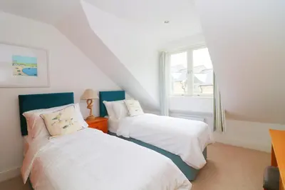 two beds in a room with a window at Beachside apartment, sea views in St Merryn