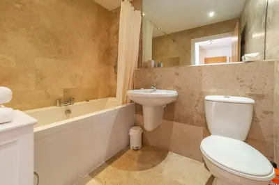 a bathroom with a toilet and a sink and a tub at Sea Folly in Perranporth