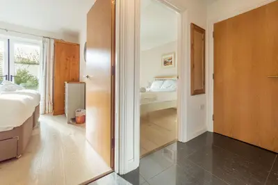 a bedroom with a bed and a door leading to a bedroom at Sea Folly in Perranporth