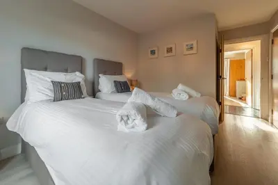 a bedroom with a large white bed with shoes on it at Sea Folly in Perranporth