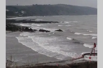 a view of a beach with waves in the water at Millendreath at Westcliff - Self Catering flat with amazing sea views in Looe