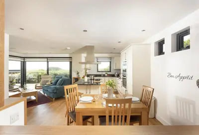 a kitchen and living room with a table and chairs at Sea Gem in St. Agnes