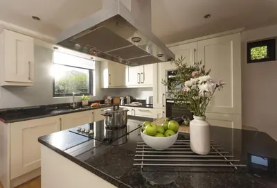 a kitchen with a bowl of apples on a counter at Sea Gem in St. Agnes