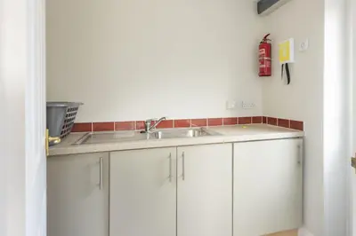 a kitchen with white cabinets and a sink at September Sea in Port Isaac