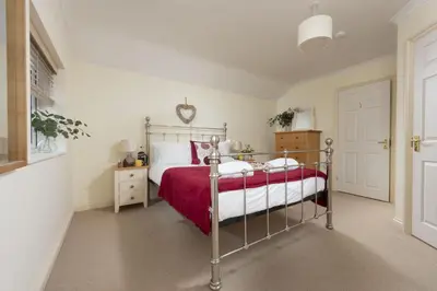 a bedroom with a bed with a red blanket at September Sea in Port Isaac