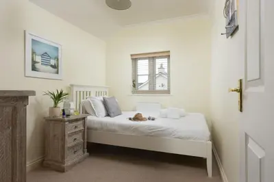 a bedroom with a bed with a cat laying on it at September Sea in Port Isaac