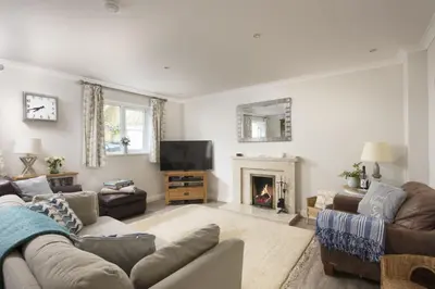 a living room with a couch and a fireplace at September Sea in Port Isaac