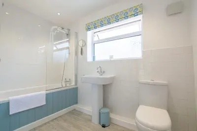 a bathroom with a toilet and a sink and a window at Sunfish in Porthtowan