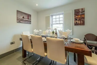 a dining room with a wooden table and chairs at Spring Tide in Porthtowan