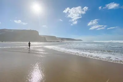 a person standing on a beach near the ocean at Spring Tide in Porthtowan