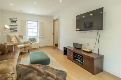 a living room with a couch and a flat screen tv at Spring Tide in Porthtowan