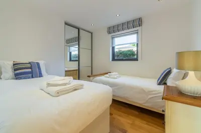 a bedroom with two beds and a window at Stargazy in St. Agnes