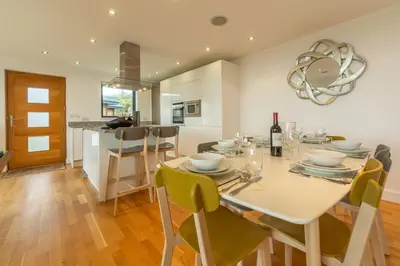 a dining room and kitchen with a table and chairs at Teyr Mor Cliff in St. Agnes