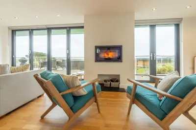 a living room with two chairs and a fireplace at Teyr Mor Cliff in St. Agnes