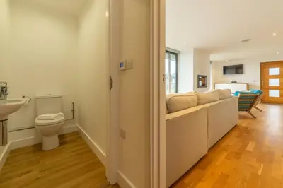 a bathroom with a couch and a toilet and a sink at Teyr Mor Cliff in St. Agnes