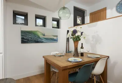 a dining room with a wooden table and chairs at The Deck House in St. Agnes