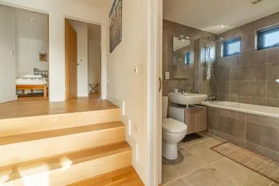 a bathroom with a toilet and a sink and a tub at The Deck House in St. Agnes
