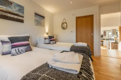 a bedroom with two beds with towels on them at The Deck House in St. Agnes