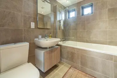 a bathroom with a toilet and a sink and a tub at The Deck House in St. Agnes