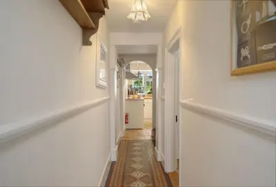 a hallway of a home with white walls and a hallway at The Boy's Cottage in Portreath