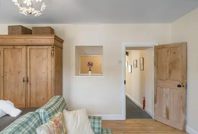 a living room with a couch and a cabinet at The Boy's Cottage in Portreath