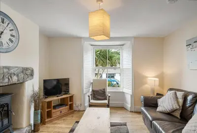 a living room with a couch and a tv at The Boy's Cottage in Portreath