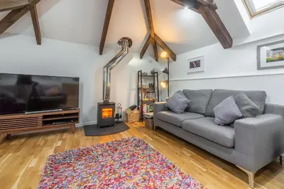 a living room with a couch and a tv and a rug at The Shires in St. Agnes