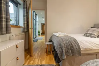a small bedroom with a bed and a window at The Shires in St. Agnes