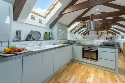 a kitchen with white cabinets and a skylight at The Shires in St. Agnes