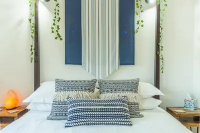 a bed with blue and white pillows on it at The Stables in St. Agnes