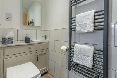 a bathroom with a toilet and a sink and a mirror at The Stables in St. Agnes