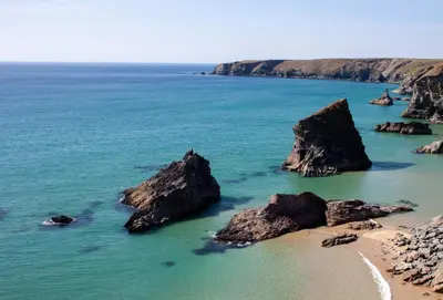 a beach with some rocks in the water at The Stables in St. Agnes