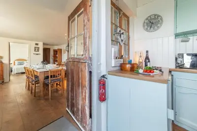 a kitchen with a table and a clock on the wall at The Watch House in Helston