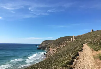 a path leading down a hill to the ocean at The Parlour in St. Agnes