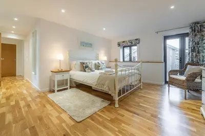 a bedroom with a bed and a table and a chair at The Parlour in St. Agnes