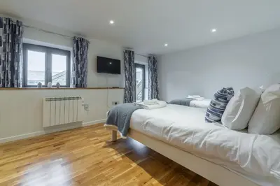 a bedroom with a large white bed and a window at The Parlour in St. Agnes
