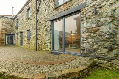 a stone building with a large window on it at The Parlour in St. Agnes