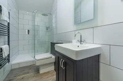 a bathroom with a sink and a toilet and a shower at The Parlour in St. Agnes