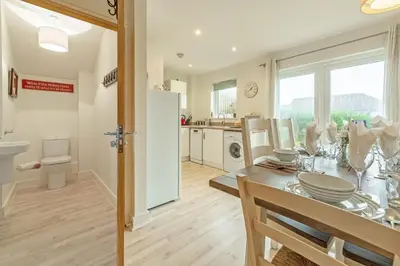 a kitchen and dining room with a table and a refrigerator at The Seahouse in Portreath