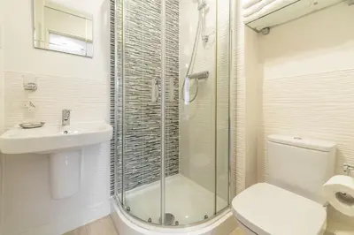 a bathroom with a shower and a toilet and a sink at The Seahouse in Portreath