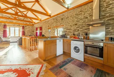 a kitchen with a washer and dryer at The Threshing Barn in Gwennap