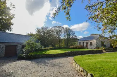 a house with a driveway in front of a yard at The Threshing Barn in Gwennap