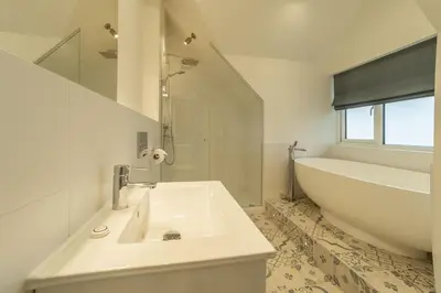 a white bathroom with a tub and a sink and a bath tub at Westaway in Portreath