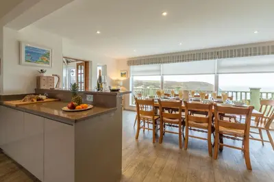 a kitchen and dining room with a table and chairs at Westerley in Portreath