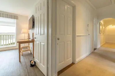 a hallway with a white door and a desk at Westerley in Portreath