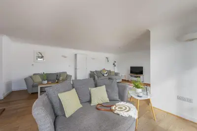 a living room with a gray couch and a table at Waterfront House in Saint Clement