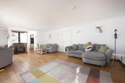 a living room with two couches and a rug at Waterfront House in Saint Clement