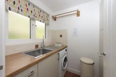 a kitchen with a sink and a washing machine at Waterfront House in Saint Clement